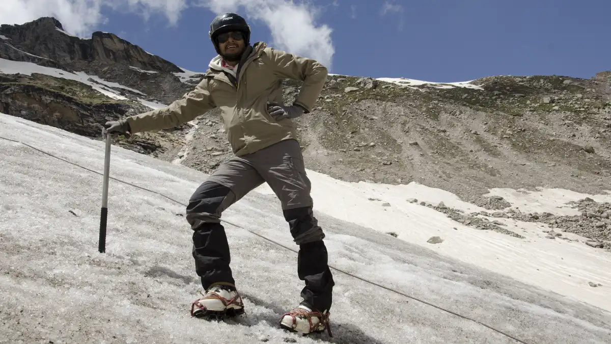 Climber on snow slope at high altitude showing terrain difficulty